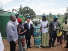 Ambassador Miyashita listens to a testimony of a beneficiary in front of a bamboo water tank